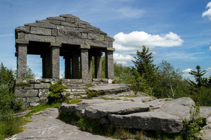 A stone structure sitting on top of a lush green hillside